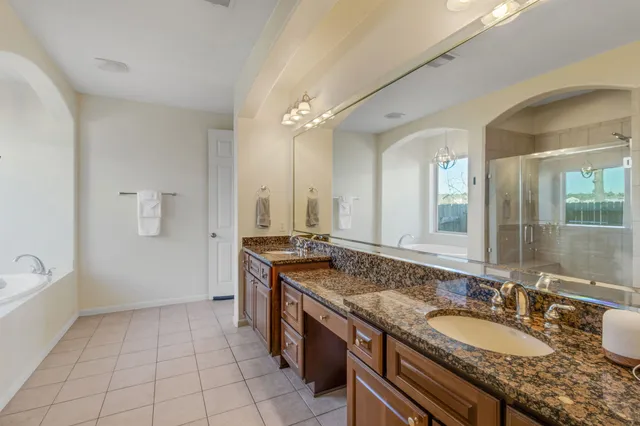 a bathroom with a granite countertop sink a large mirror and a shower