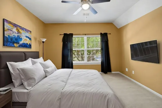 a spacious bedroom with a bed a couch and a large window