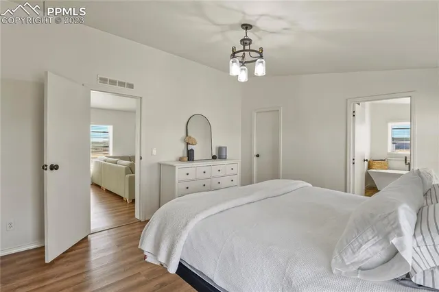 a bedroom with a large bed and a chandelier