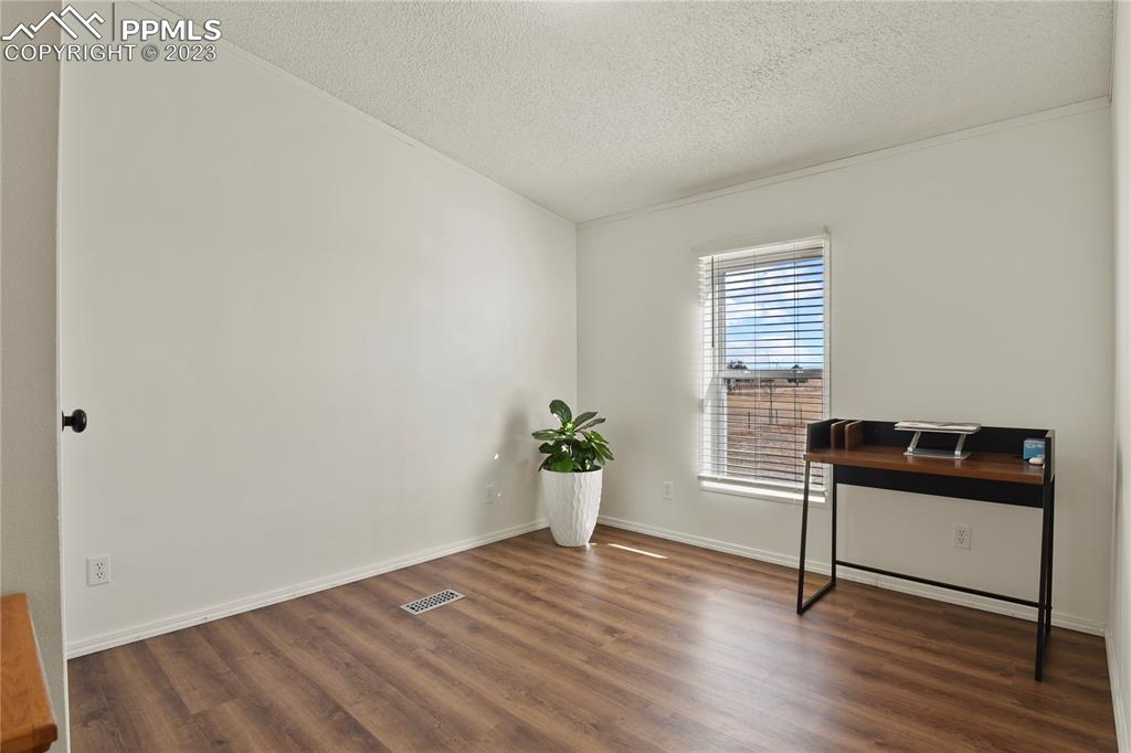 17755 Sage Crest Road Peyton, CO 80831 - Photo 26 of 37 a view of an empty room with a window and wooden floor