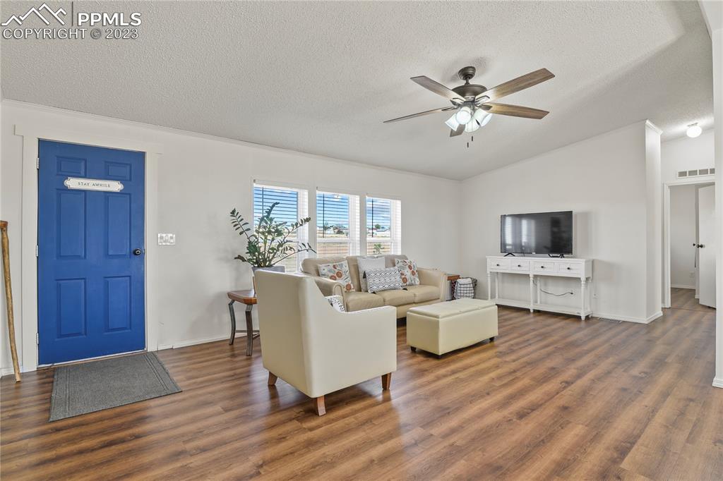 17755 Sage Crest Road Peyton, CO 80831 - Photo 6 of 37 a living room with furniture a flat screen tv and a wooden floor