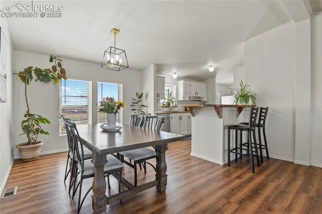 a dining room with furniture a chandelier and wooden floor