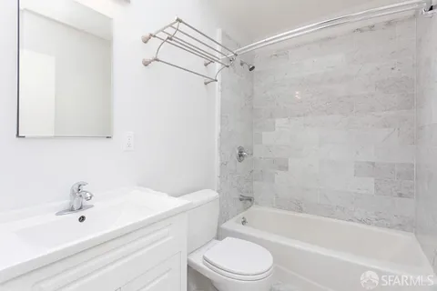 a bathroom with a bathtub shower sink vanity and toilet