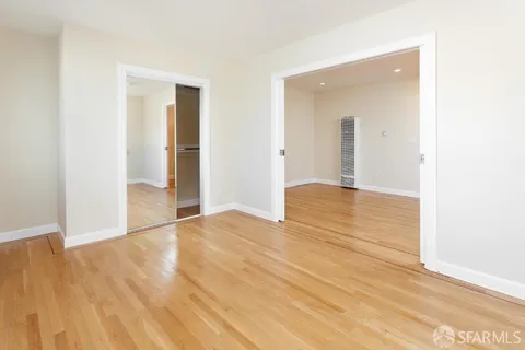 a view of an empty room with wooden floor