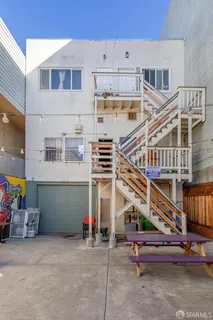 a view of a house with a small yard and potted plants