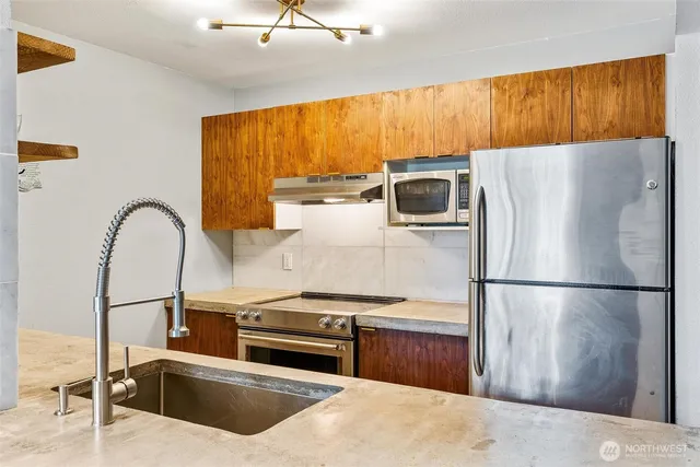 a kitchen with a refrigerator and a stove top oven