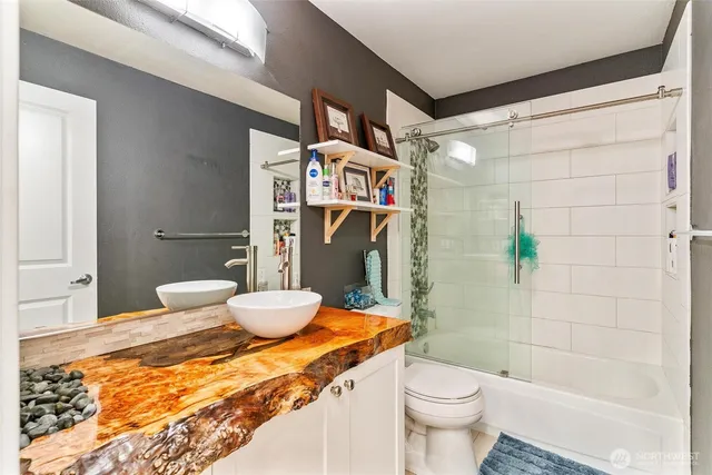 a bathroom with a granite countertop sink a toilet and shower