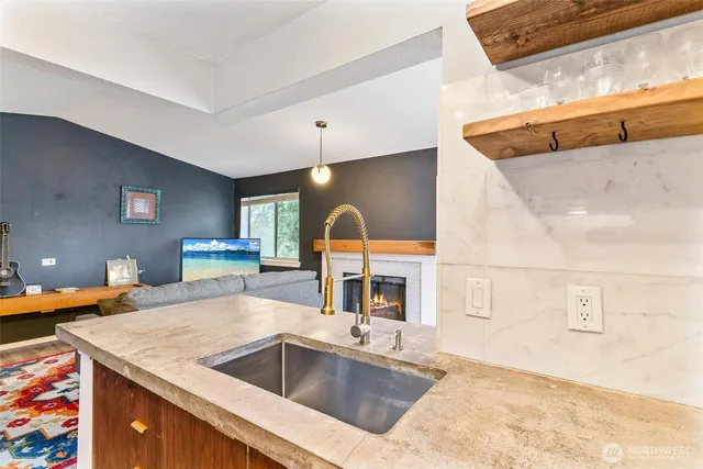 a kitchen with a sink and a stove with wooden floor