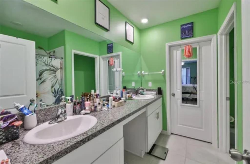 9317 Lemon Drop Loop Ruskin, FL 33573 - Photo 11 of 13 a bathroom with a granite countertop sink and a mirror