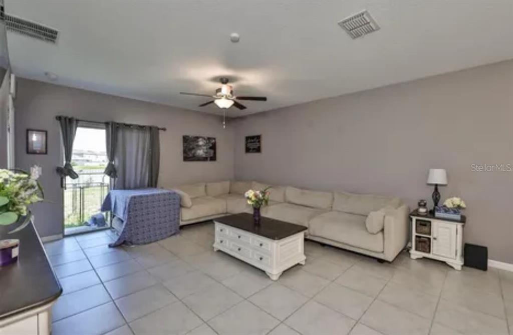 9317 Lemon Drop Loop Ruskin, FL 33573 - Photo 7 of 13 a living room with furniture and a chandelier