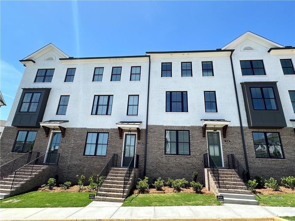 a front view of a house with yard and parking