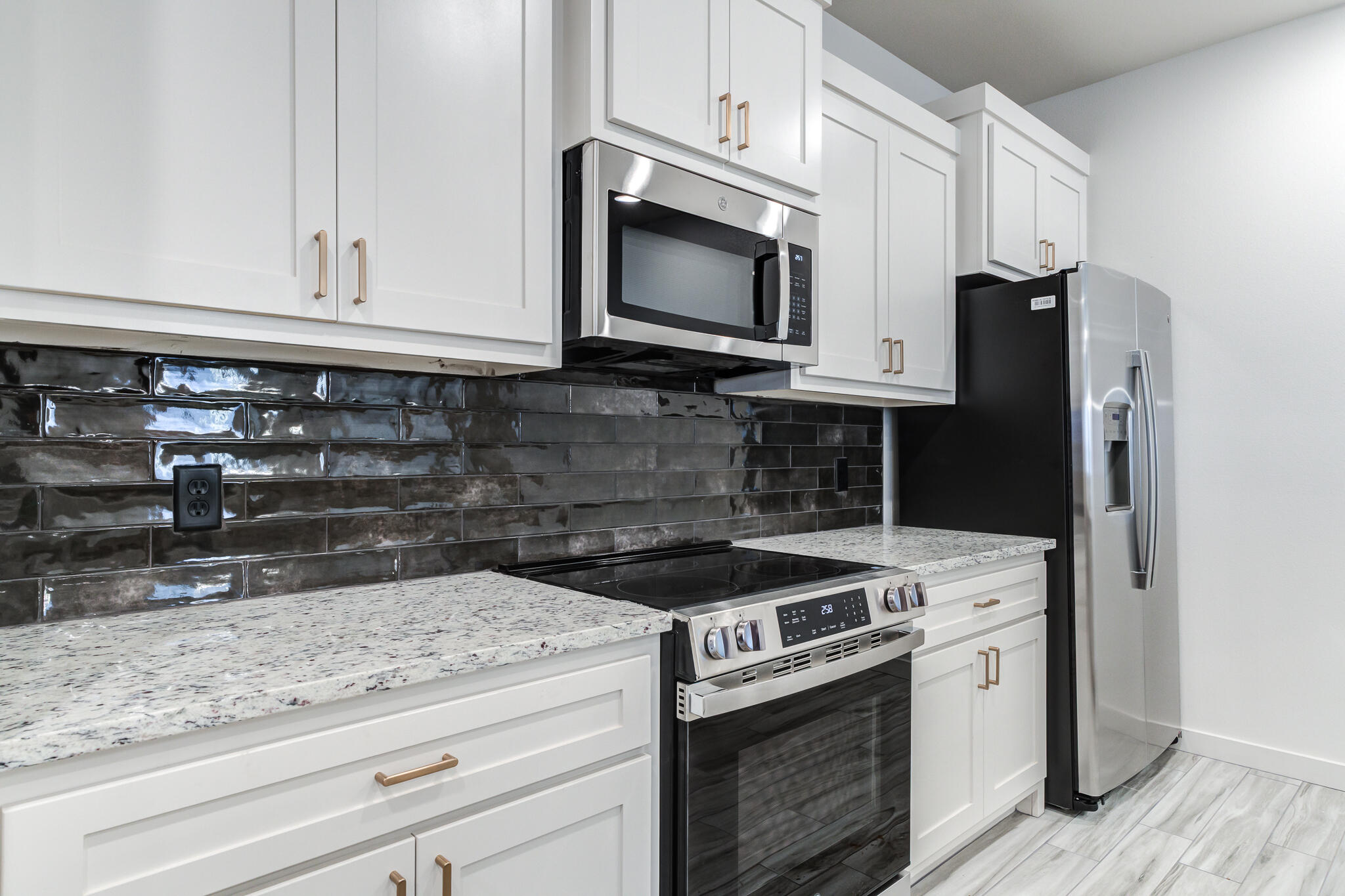 7044 41st Street Lubbock, TX 79407 - Photo 14 of 22 a kitchen with granite countertop cabinets and steel stainless steel appliances