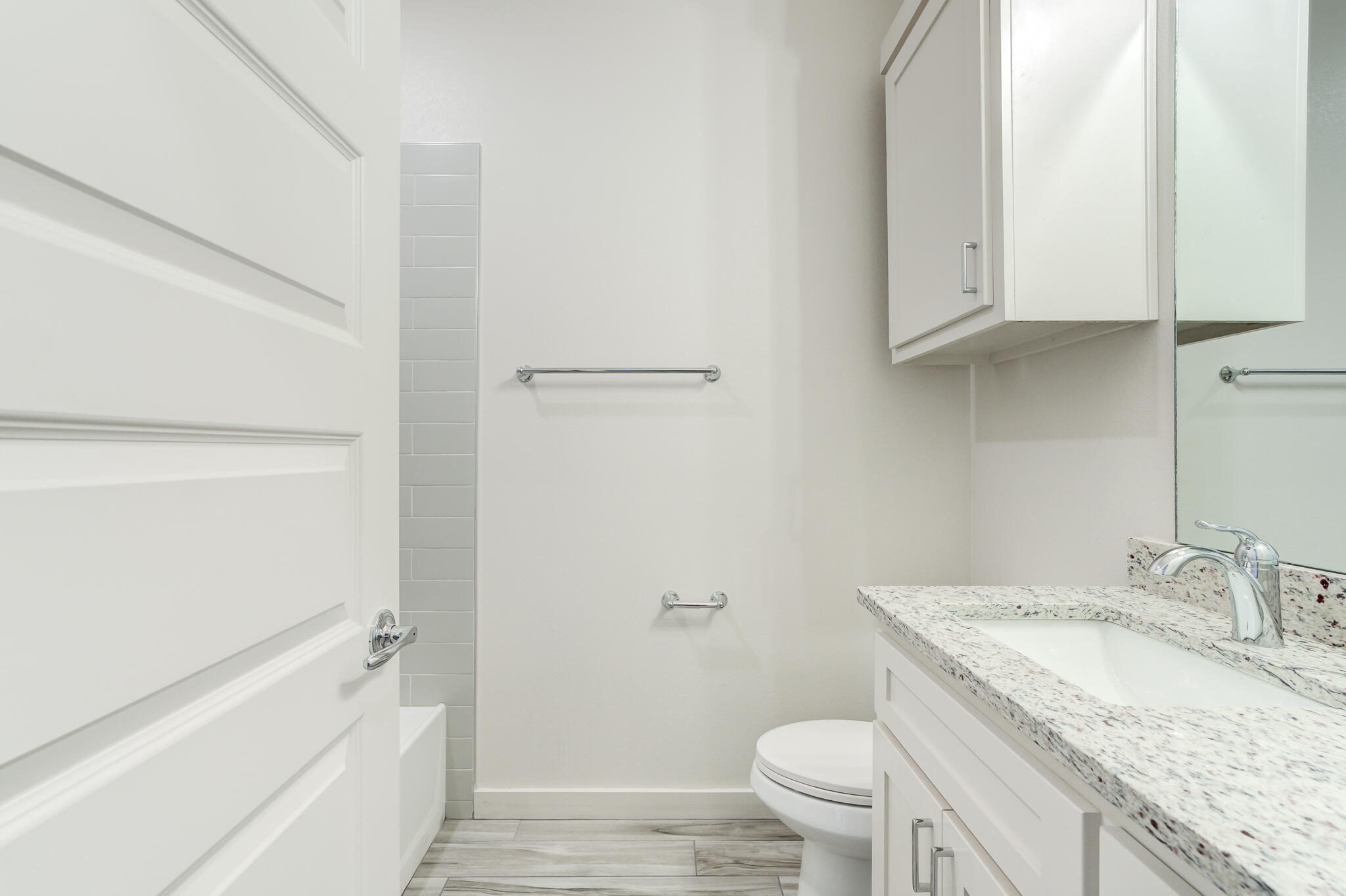 7044 41st Street Lubbock, TX 79407 - Photo 18 of 22 a bathroom with a granite countertop sink a toilet and bathtub