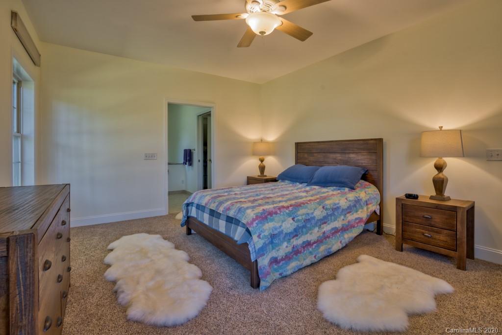 475 Gilbert Road Columbus, NC 28722 - Photo 20 of 45 a bedroom with a bed and a chandelier