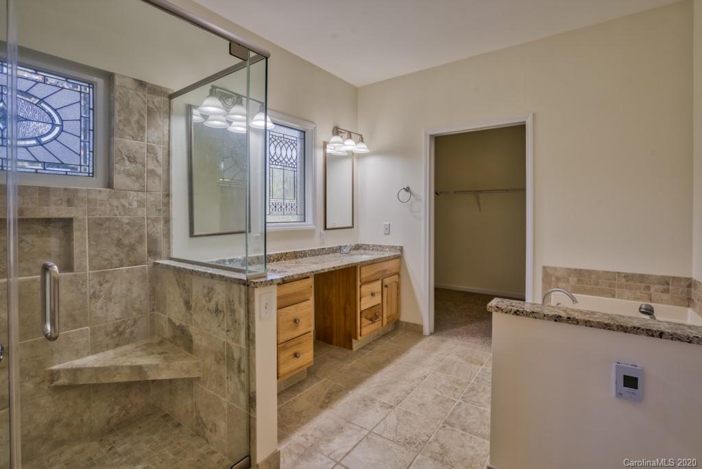 475 Gilbert Road Columbus, NC 28722 - Photo 21 of 45 a bathroom with a double vanity sink a mirror and a shower