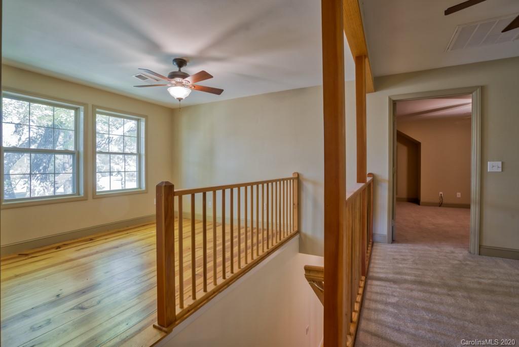 475 Gilbert Road Columbus, NC 28722 - Photo 27 of 45 a view of a hallway with wooden floor and chandelier