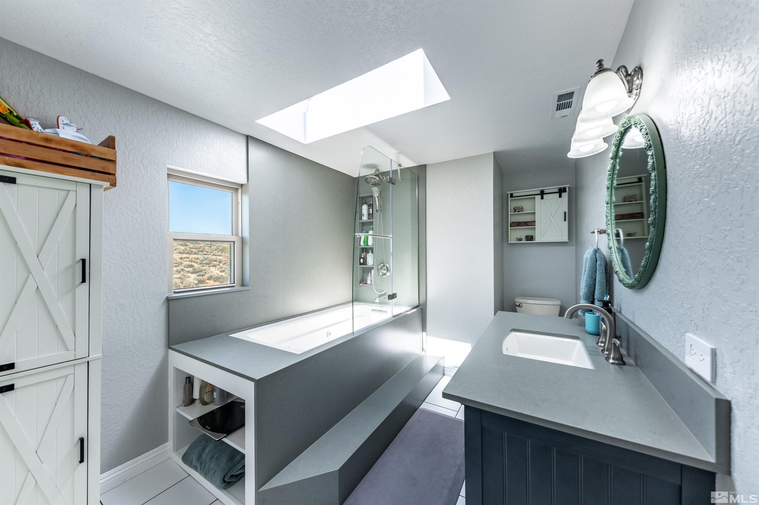 6105 Anniversary Road Reno, NV 89510 - Photo 17 of 40 a en suite bathroom with a sink double vanity and a mirror