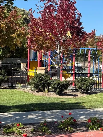a front view of a building with a yard and a fountain