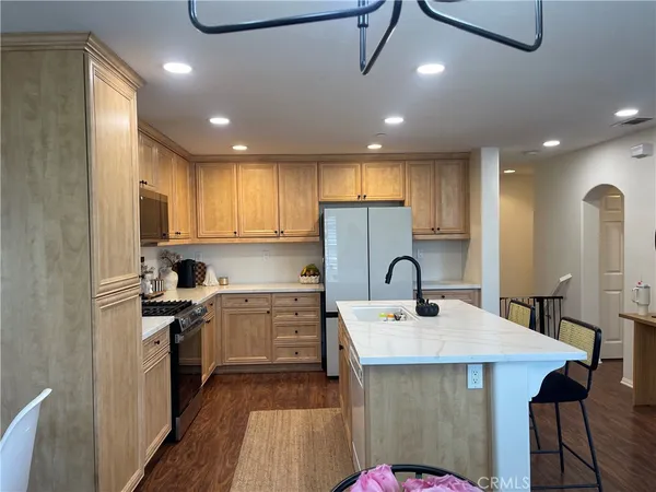 a kitchen with kitchen island a sink stainless steel appliances and cabinets