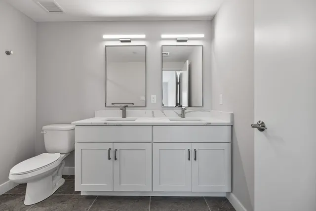 a bathroom with a toilet a sink and mirror