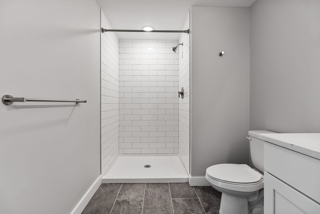 59 Mill Street, Unit 111 Woburn, MA 01801 - Photo 17 of 18 a bathroom with a shower and a toilet