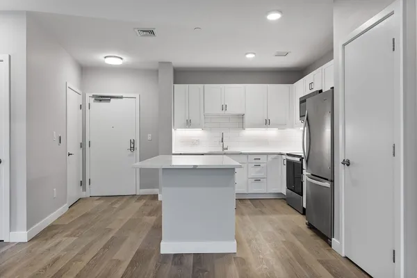 a kitchen with white cabinets and stainless steel appliances