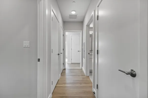 a view of a hallway with wooden floor