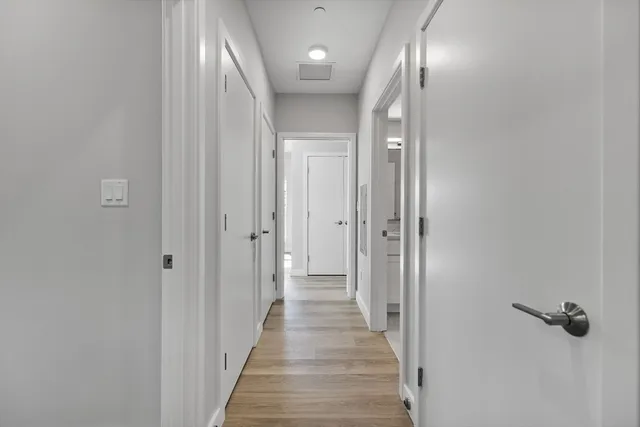 a view of a hallway with wooden floor