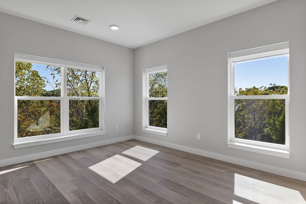 59 Mill Street, Unit 111 Woburn, MA 01801 - Photo 7 of 18 a view of an empty room with wooden floor and a window