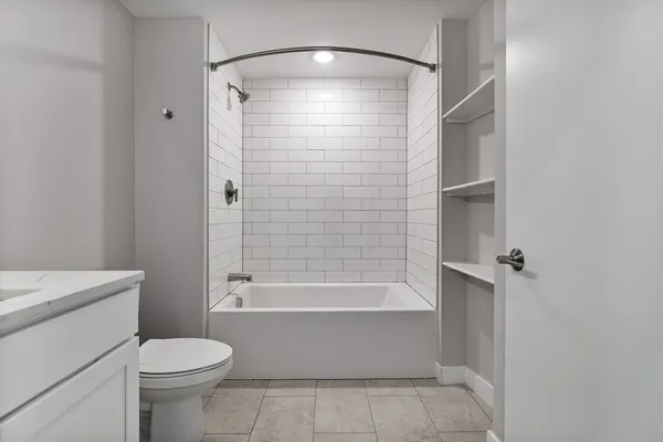 a bathroom with a shower a toilet and a tub