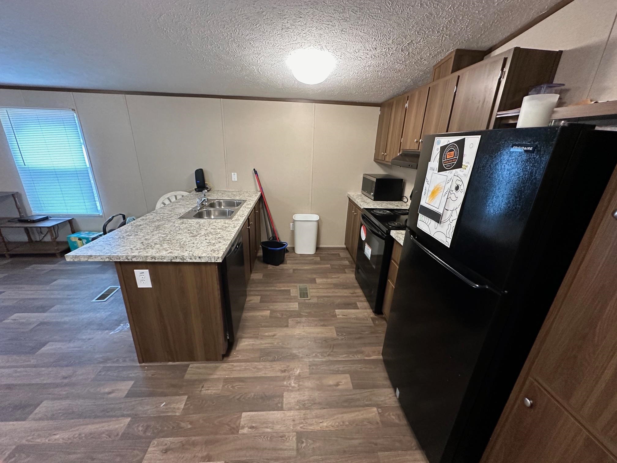 1696 Hardin Graveyard Road Adamsville, TN 38310 - Photo 14 of 25 a kitchen with stainless steel appliances granite countertop a sink stove and refrigerator