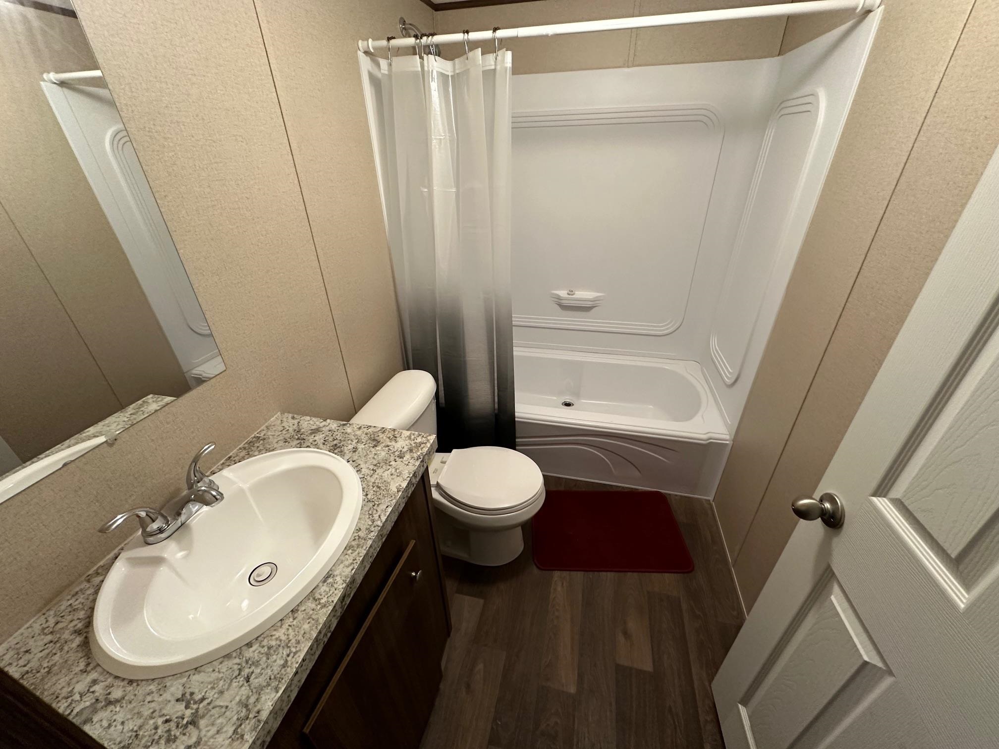 1696 Hardin Graveyard Road Adamsville, TN 38310 - Photo 2 of 25 a bathroom with a granite countertop sink toilet and shower