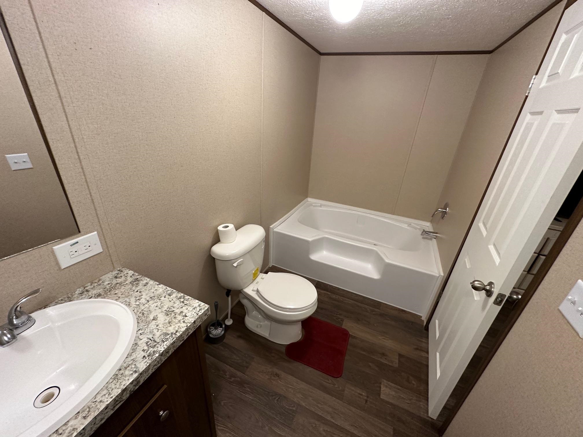 1696 Hardin Graveyard Road Adamsville, TN 38310 - Photo 10 of 25 a bathroom with a granite countertop sink toilet and shower