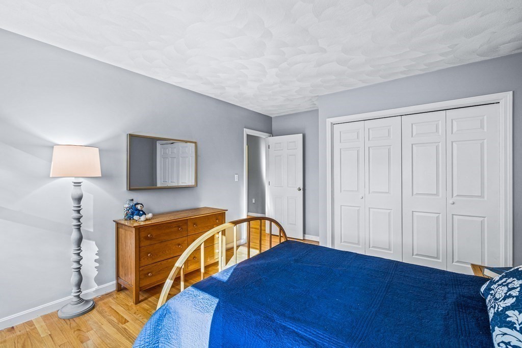 18 Ravens Bluff Andover, MA 01810 - Photo 28 of 41 a bedroom with a bed and a lamp on dresser