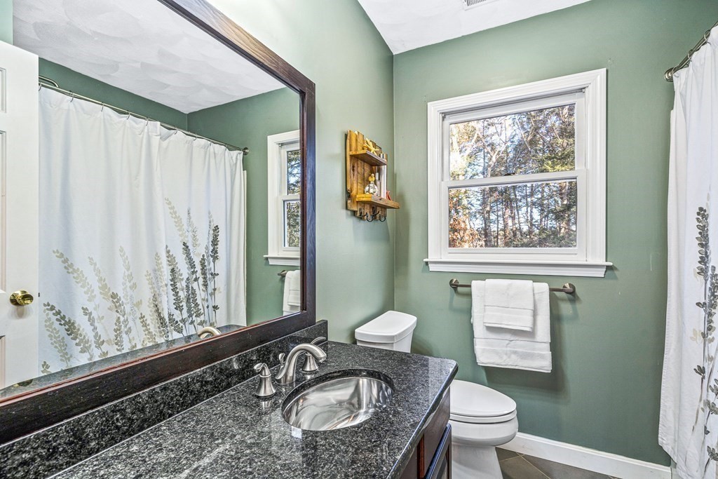 18 Ravens Bluff Andover, MA 01810 - Photo 29 of 41 a bathroom with a granite countertop sink a mirror a toilet and a window