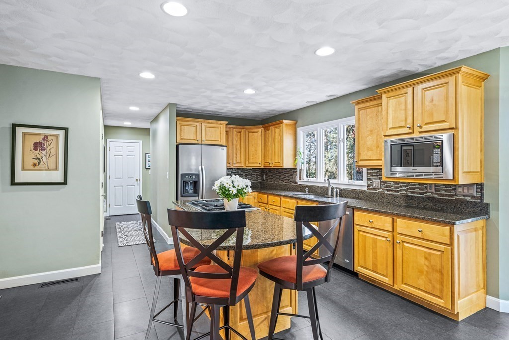 18 Ravens Bluff Andover, MA 01810 - Photo 4 of 41 a kitchen with stainless steel appliances granite countertop wooden cabinets a dining table and chairs