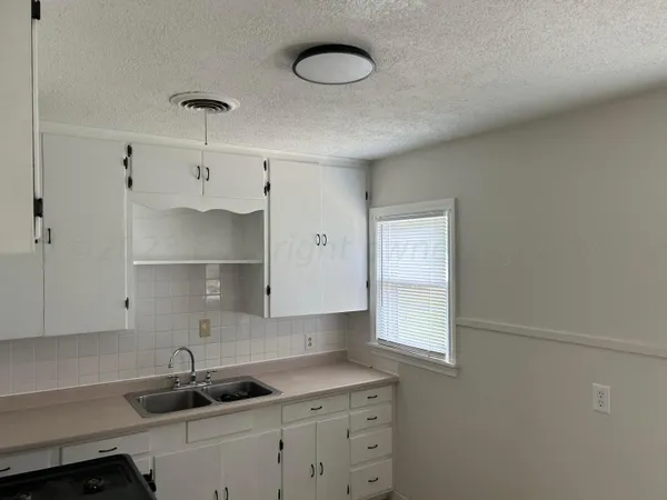 a kitchen with cabinets appliances and a window