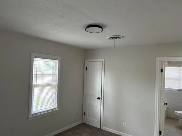 an empty room with windows and closet