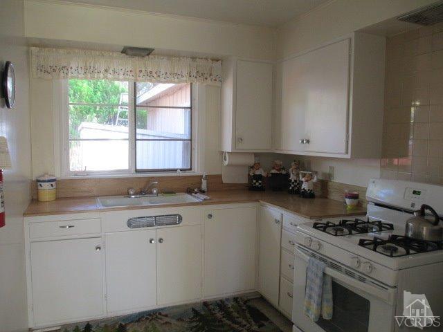 1225 South Rice Road, Unit 5 Ojai, CA 93023 - Photo 40 of 41 a kitchen with a sink stove top oven and cabinets