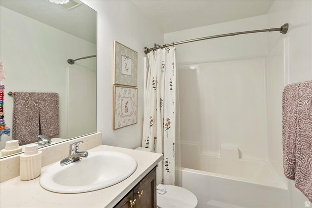 3916 South Sage Wood Avenue Mapleton, UT 84664 - Photo 12 of 33 Bathroom featuring a single vanity with an integrated sink, polished chrome faucet, and wood-finish cabinetry