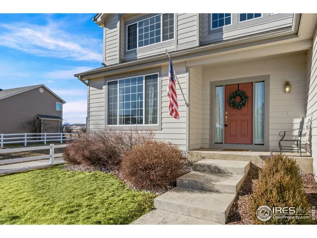 a living room with furniture a fireplace and a large window
