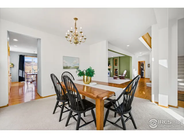 a view of a dining room and livingroom with furniture wooden floor a chandelier