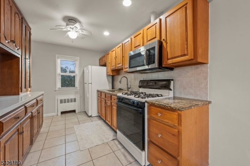 47 River Road Chatham, NJ 07928 - Photo 5 of 21 a kitchen with stainless steel appliances granite countertop a stove a sink and a refrigerator