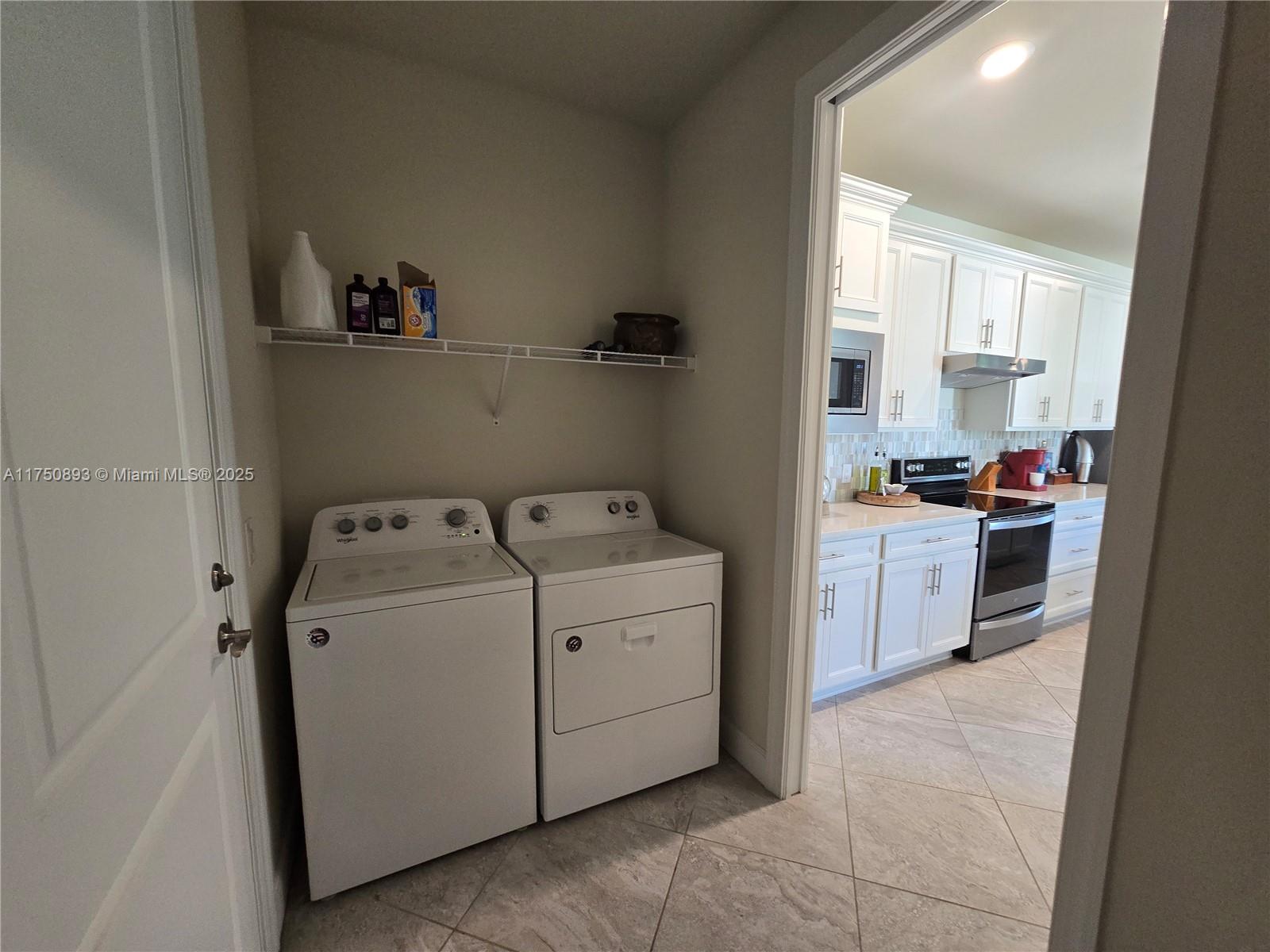 Ave Maria Immokalee, FL 34142 - Photo 7 of 21 a utility room with cabinets washer and dryer