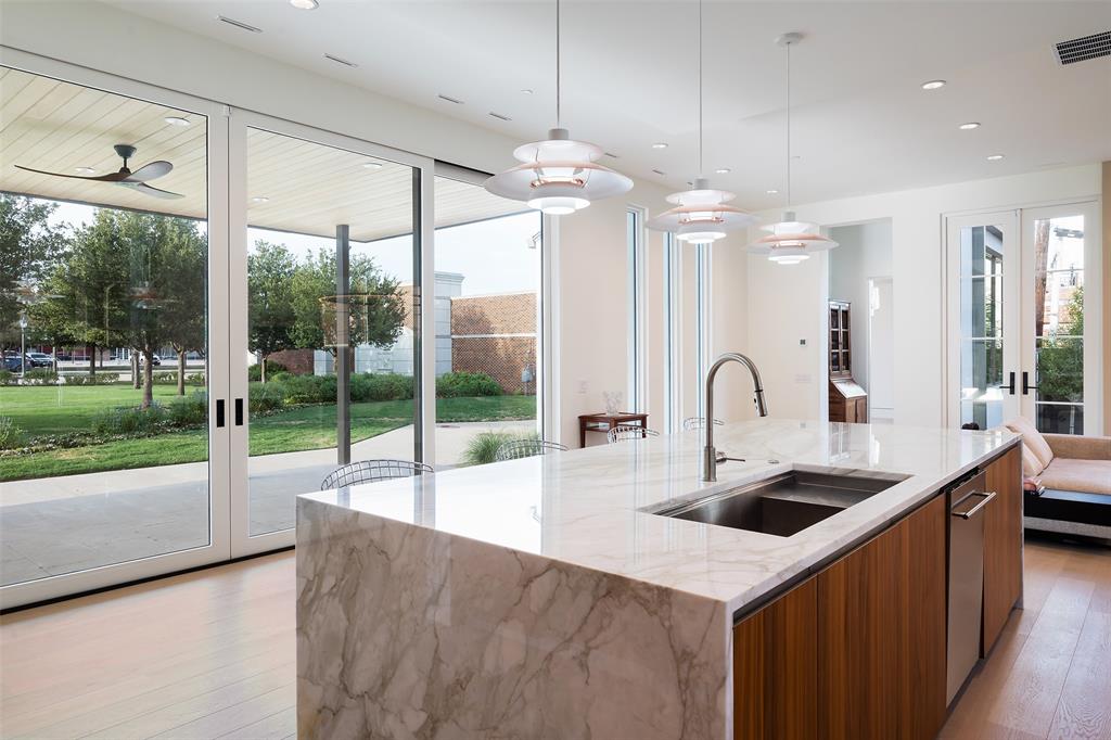 5048 Airline Road Highland Park, TX 75205 - Photo 18 of 36 a kitchen with kitchen island a large window cabinets a sink and stainless steel appliances