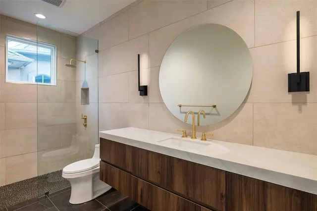 a bathroom with a sink a toilet and shower