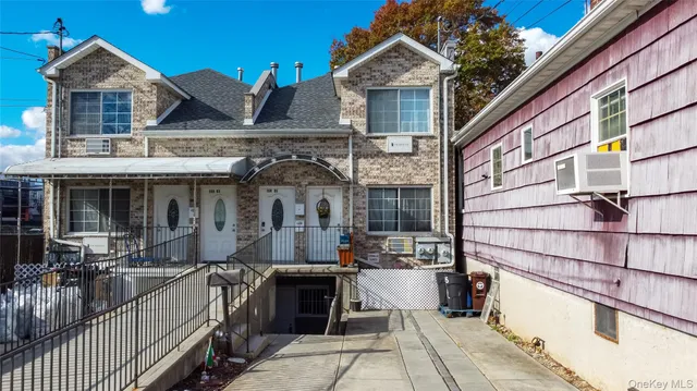 a view of a house with a barbeque and large trees