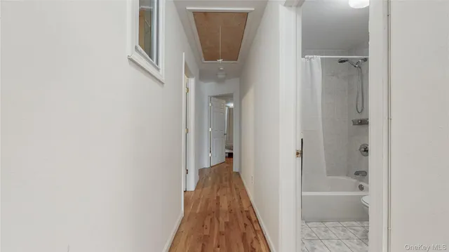 a view of a hallway with wooden floor and a glass door