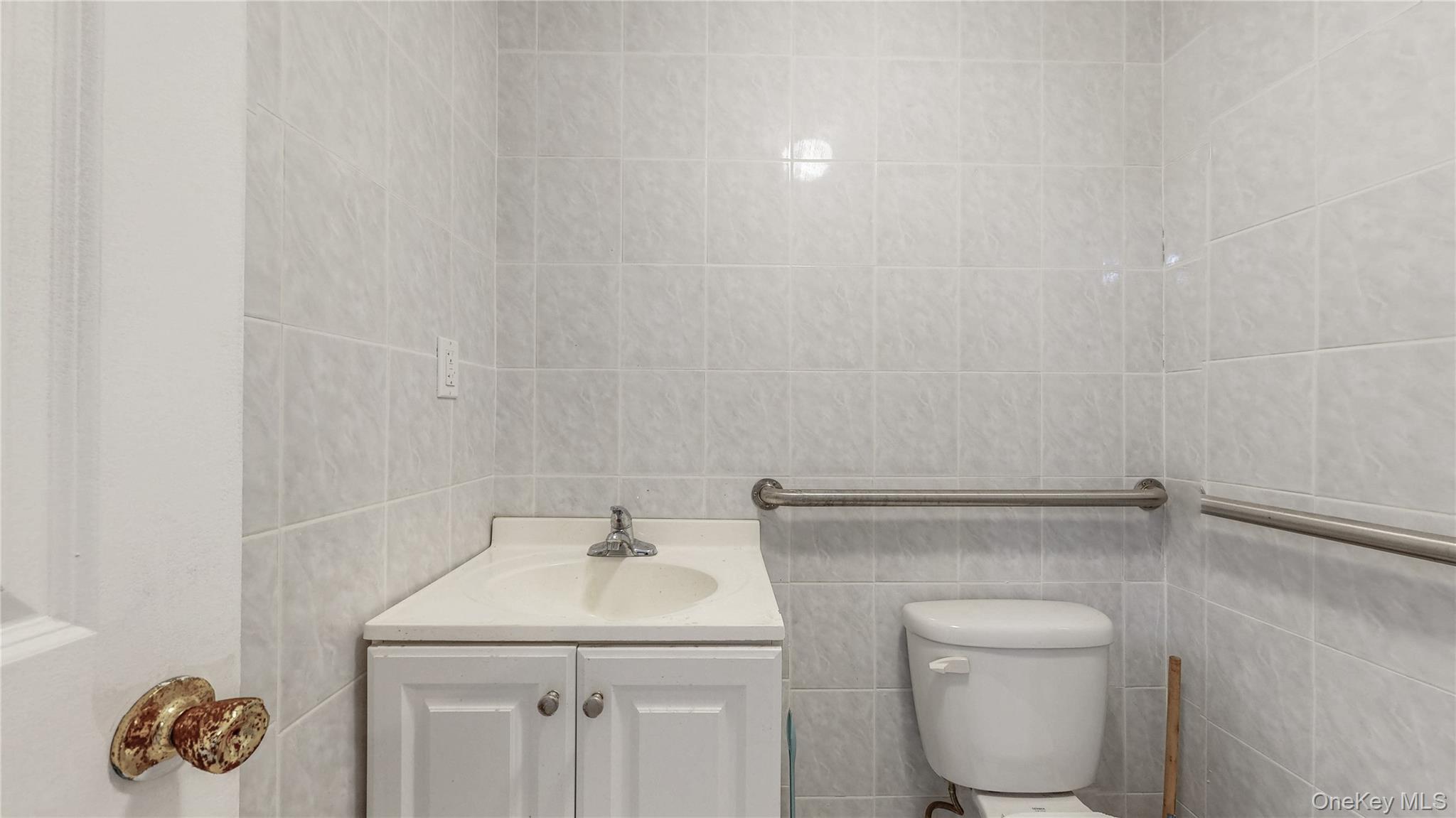 150-55 14th Road Queens, NY 11357 - Photo 29 of 39 a bathroom with a sink a toilet and a mirror