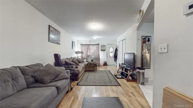a living room with furniture a flat screen tv and a table
